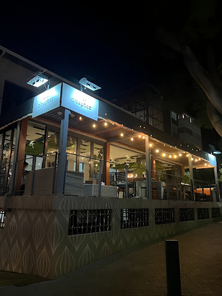 Next Chapter Restaurant's covered patio on Florida Road, strung with warm lights and sunflowers on every table