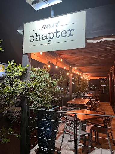 Next Chapter Restaurant's sign and patio tables lit up on Florida Road at night